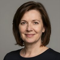 Портрет уверенного и дружелюбного стоматолога клиники Митино 3 на нейтральном размытом фоне